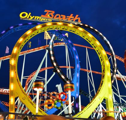 A twisted hoop ride with colourful lights at night.