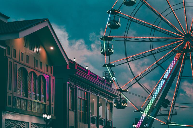 An image of a Giant Wheel in front of a house building.
